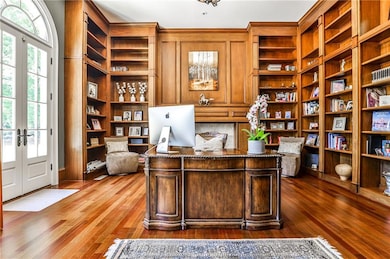 Library/office with extensive built-in shelving, fireplace and French doors that access the front terrace.