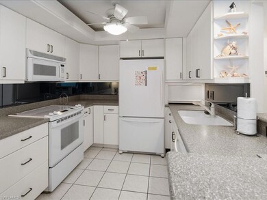 Kitchen featuring white appliances, ceiling fan, s