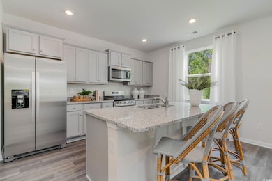 Kitchen with gray cabinets, a sink, light stone co