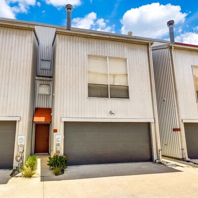 View of gated townhome with a garage