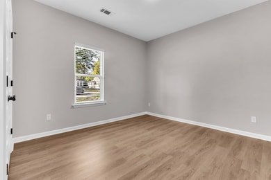 Unfurnished room featuring light wood finished floors and baseboards