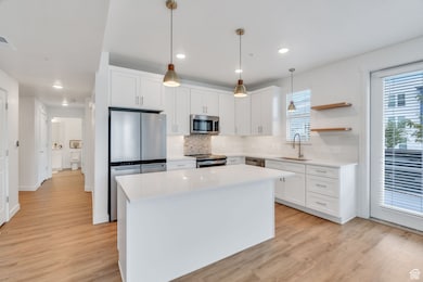 Kitchen featuring tasteful backsplash, white cabinets, open shelves, and recessed lighting