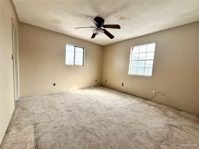 Spare room featuring light carpet, a healthy amount of sunlight, and a textured ceiling