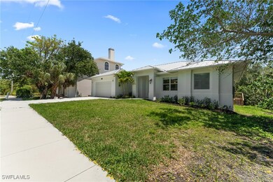 View of front of home featuring stucco siding, driveway, a front yard, and a chimney