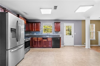 Kitchen featuring stainless steel appliances, dark brown cabinets, dark countertops, and decorative backsplash