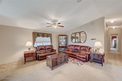 Carpeted living room featuring vaulted ceiling and