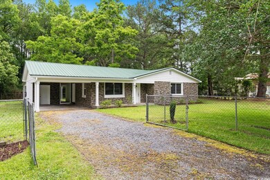 Ranch-style house featuring driveway, stone siding