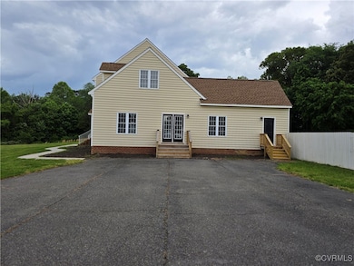 Back of property with a shingled roof and fence