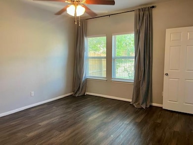 Spare room featuring dark wood finished floors and a ceiling fan