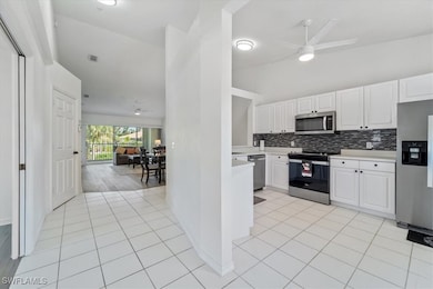 Kitchen featuring stainless steel appliances, a ceiling fan, light countertops, and decorative backsplash