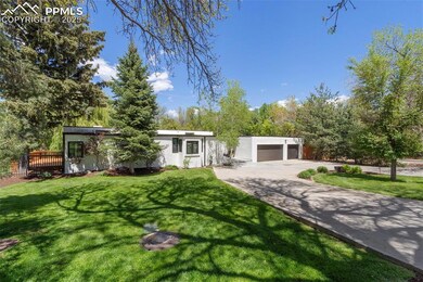 Mid-century modern home with stucco siding, a front lawn, and concrete driveway