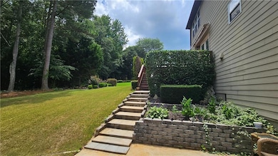 View of grassy yard featuring stairway