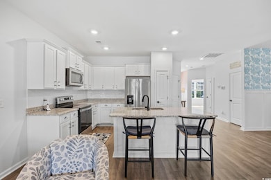Kitchen with white cabinetry, a sink, appliances w
