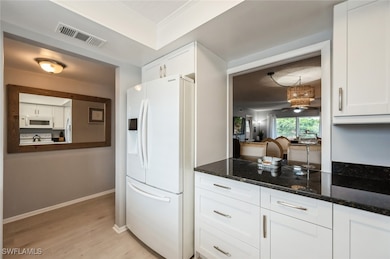 Kitchen featuring white appliances, white cabinets