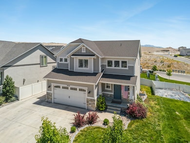 View of front of home featuring a porch, stone siding, concrete driveway, a shingled roof, and a garage
