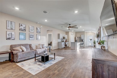 Living room with ceiling fan, light wood finished