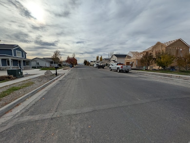 View of asphalt street featuring sidewalks, curbs, and a residential view