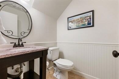 Bathroom with wainscoting and lofted ceiling