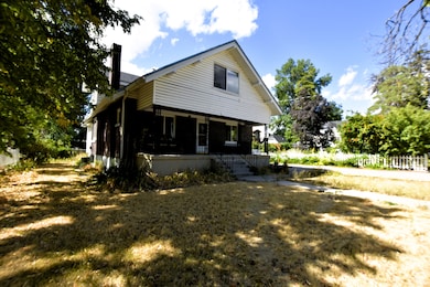 View of home's exterior featuring covered porch and a chimney