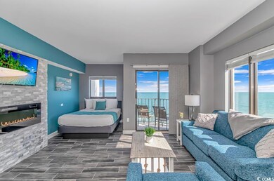 Bedroom featuring a water view, a glass covered fireplace, wood finish floors, and multiple windows