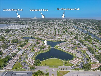 Aerial view of the beautifully maintained senior condo community showcasing landscaped grounds, walking paths, and surrounding green spaces. Nearby parks can be seen in the background, highlighting the community’s close proximity to outdoor recreation and peaceful natural surroundings.