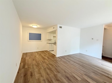 Unfurnished living room featuring wood finished f