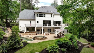 Rear view of house featuring stairs, an in-ground 