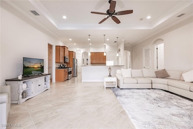 Living room with a raised ceiling, ceiling fan, an