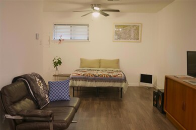 Bedroom with wood finished floors, baseboards, an