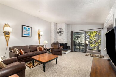 Carpeted living room with lofted ceiling and a fir