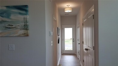 View down hallway to laundry, 1/2 bath & garage