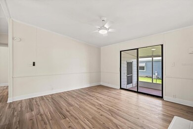 Family Room with Double Sided Wood Burning Fireplace (13.5x14.5) looking out to the Carport Side Porch and Storage Rooms