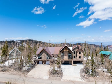View of front facade with stone siding, concrete driveway, and a mountain view