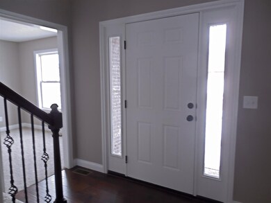 The foyer has a staircase with wrought iron spindl