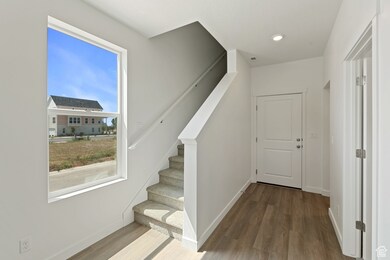 Stairs featuring wood finished floors and recessed lighting