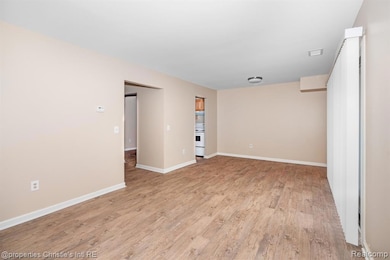 Unfurnished room with light wood finished floors and baseboards