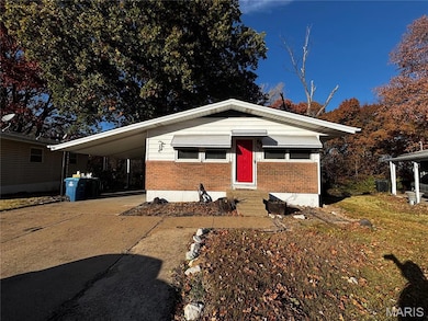 View of front facade featuring driveway, brick siding, a carport, and entry steps