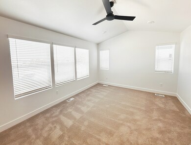 Unfurnished room with lofted ceiling, light colored carpet, and ceiling fan