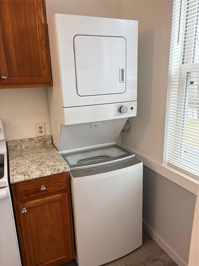 Laundry area featuring estacked washer and dryer and wood finished floors