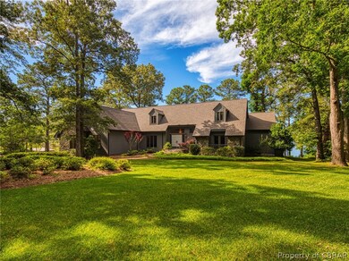 Lush lawn, mature landscaping & trees frame this s