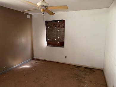 Unfurnished room featuring a ceiling fan and baseboards