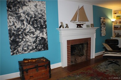 Light, bright living room with built in bookcases, wood burning fireplace, crown molding & hardwood floors!
