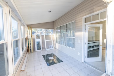 Unfurnished sunroom featuring lofted ceiling
