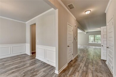 Hallway featuring wood finished floors and ornamental molding