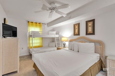 Bedroom with light carpet, a ceiling fan, and a textured ceiling