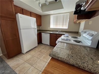 Kitchen featuring white appliances, extractor fan,