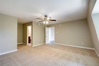Empty room with a ceiling fan, light colored carp