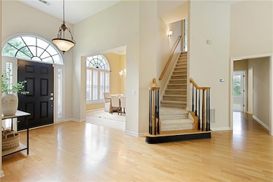 Spacious entry hall with hardwood floors and open 