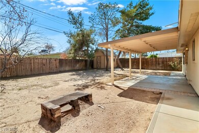 Big backyard with a covered patio, a shed, and ple