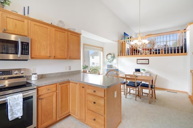 The upper level living room overlooks the kitchen under the tall ceilings.